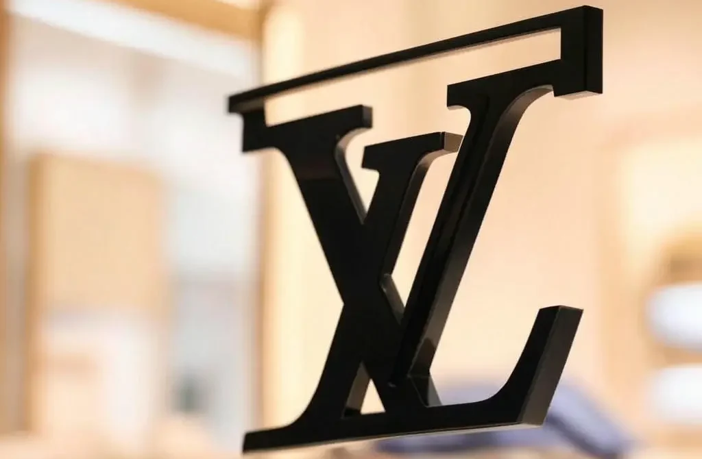 نمای نزدیک از لوگوی مشکی لویی ویتون با پسزمینه روشن و لوکس
