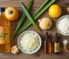 مواد طبیعی برای درمان میخچه بدون درد، شامل سرکه سیب، آلوئه‌ورا، سیر، لیمو و روغن‌ها روی سطح چوبی.